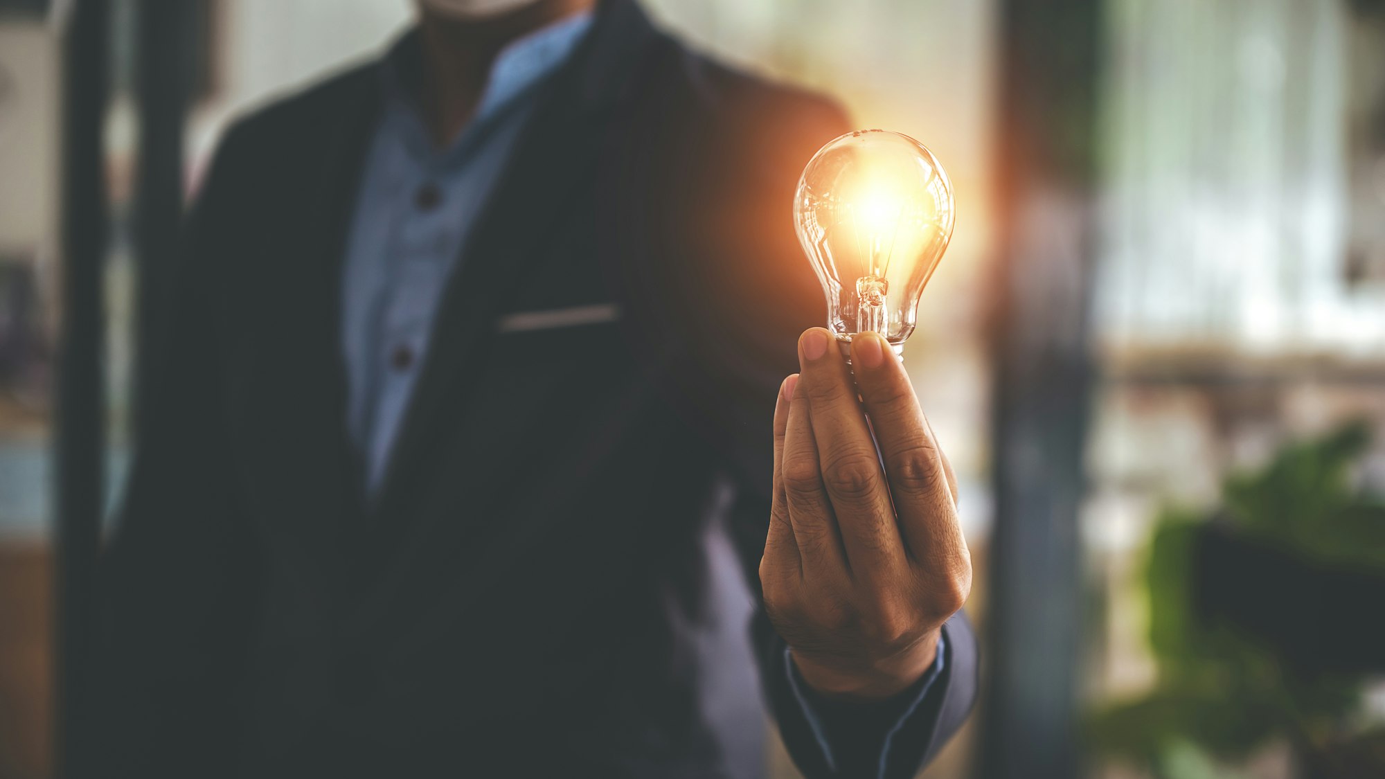 Hand holding a light bulb. Innovative concept with inspiration and energy saving concept.